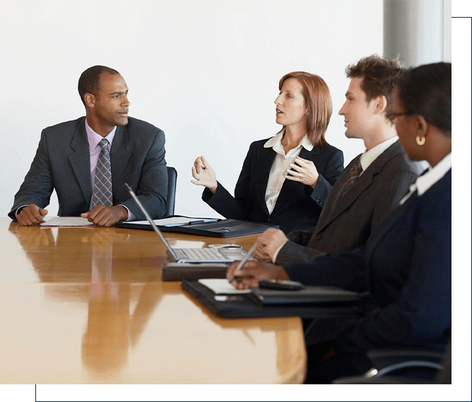 Four professionals engaged in a discussion during a business meeting.