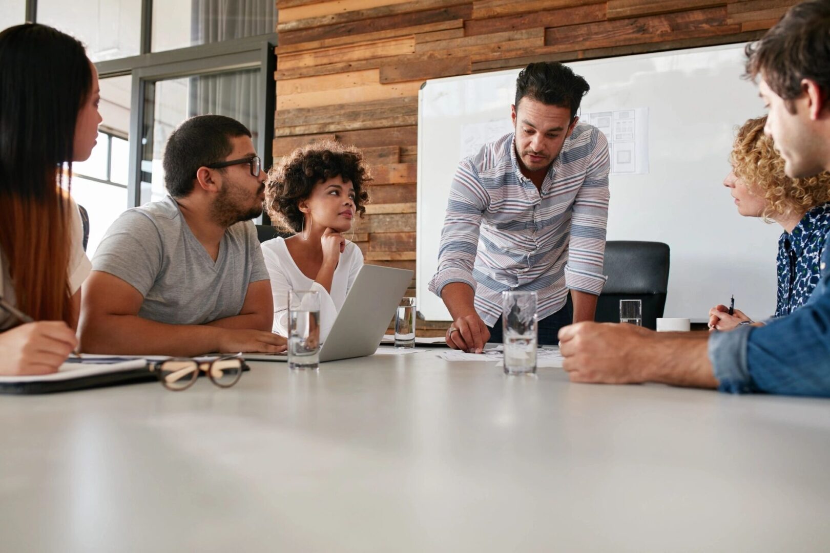 Diverse team engaged in a collaborative discussion around a meeting table.